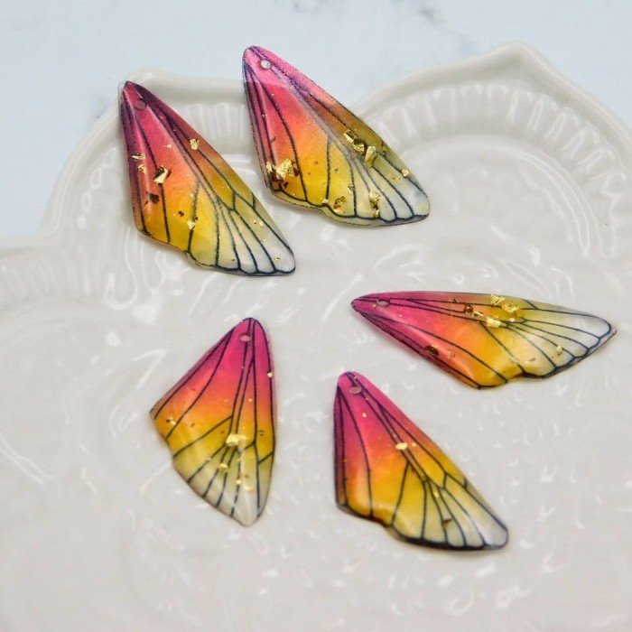 Zawieszka z żywicy skrzydło motyla 25x12mm różowo-żółta (1szt.)